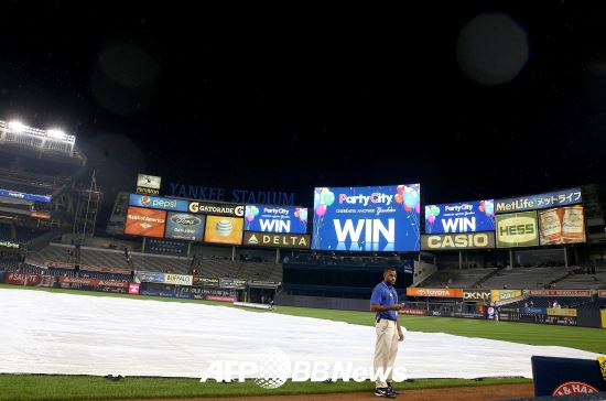 <b>“끝났다! 덮어라 덮어”</b> 24일 미국 뉴욕 양키스타디움에서 열린 메이저리그 3차전이 뉴욕 양키스의 강우콜드게임 승으로 끝났다. 진행요원들이 그라운드를 천으로 덮고 있다. / ⓒAFP BBNews = News1