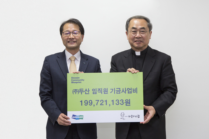 15일 서울 명동성당에서 김윤건 (주)두산 전무(왼쪽)가 손희송 바보의나눔 이사장에게 (주)두산 임직원이 모은 사회공헌 기부금 약 2억원을 전달한 뒤 기념촬영을 하고 있다.