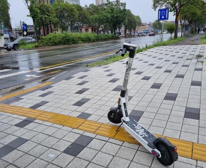 빗길 미끄러운 보도에 방치된 킥보드 ‘위험천만’