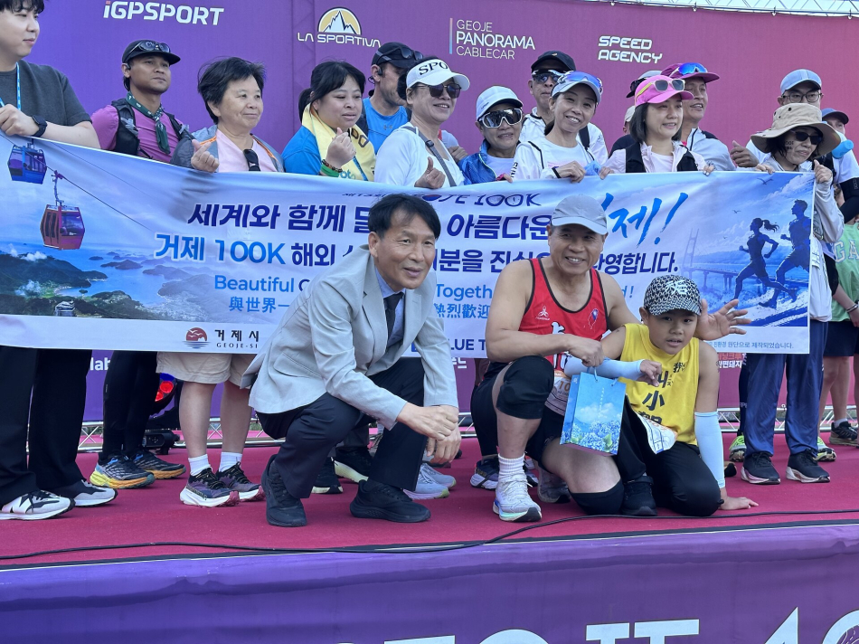 거제 100K 트레일러닝대회 외국인 참가자들이 기념사진을 촬영하고 있다. 앞줄에 호천정씨와 아들 호포언군이 앉아 있다. 거제시 제공