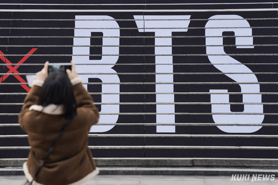 외국인 관광객이 서울 종로구 세종문화회관 계단에 부착된 그룹 방탄소년단(BTS) 컴백 공연 홍보물 앞에서 사진을 찍고 있다. 남동균 기자