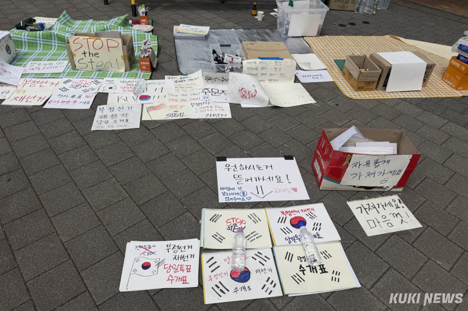 6·3 지방선거 투표용지 부족 사태를 규탄하며 재선거를 요구하는 ‘잠실 개표소 봉쇄 시위’가 계속되고 있는 9일 서울 송파구 올림픽공원 핸드볼경기장 일대에 시민들이 자유롭게 가져가도록 만든 손팻말이 바닥에 놓여 있다. 유병민 기자